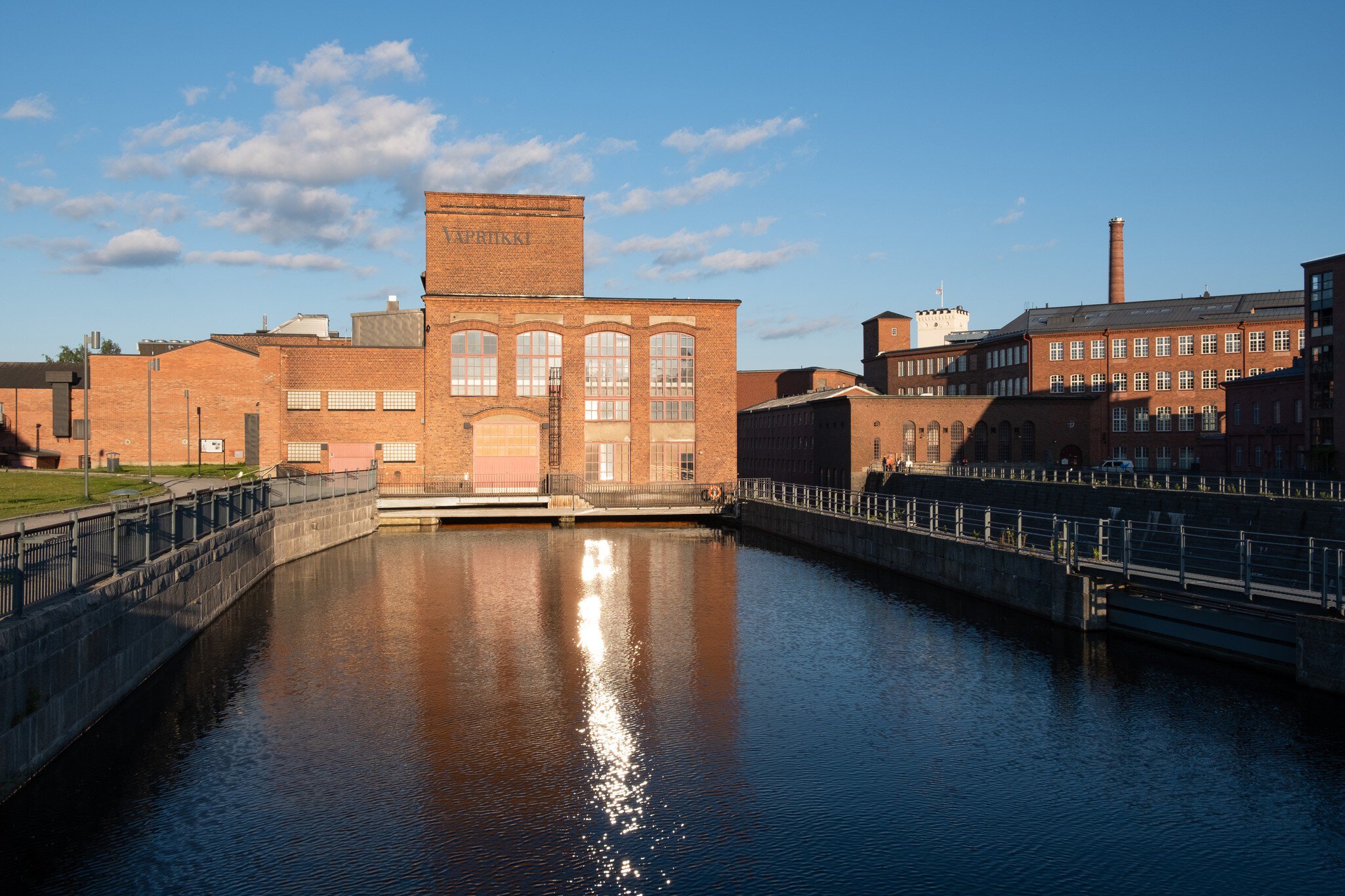 Tampere, Finland - June 2019: Vapriikki Museum, Tampella building. View over Tammerkoski river in warm sunlight