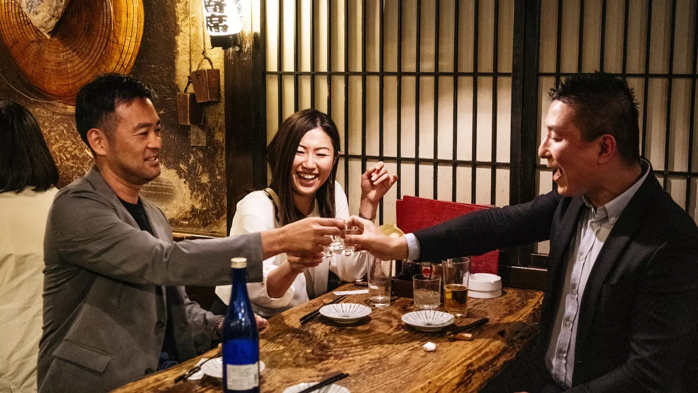 Portrait of Japanese friends celebrating together with Saki