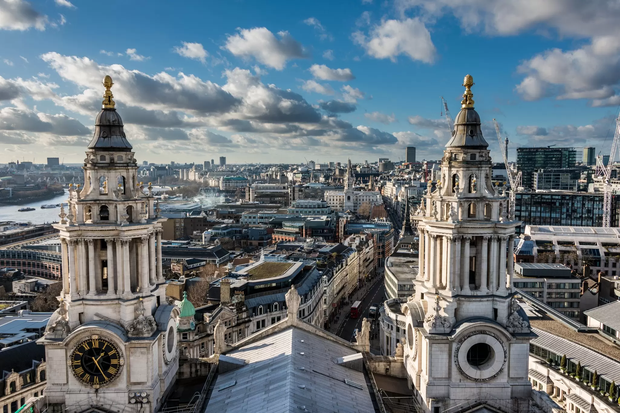 Two church bell towers and a rooftop giving way to a city beyond: Views from the dome at St Paul's Cathedral. 