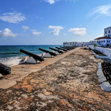Cannons overlooking from Cape Coast Castle, a fortification in Ghana built by Swedish traders for trade in timber and gold. Later the structure was used in the trans-Atlantic slave trade.
144162838
africa, african culture, african descent, antique, architecture and buildings, atlantic ocean, beach, black, bodies of water, cannon, cape, castle, coast, coastline, concepts and ideas, dutch culture, elmina, fort, fortified wall, ghana, guinea, gun, history, iron, looking at view, military, nature, netherlands, nobody, old, old-fashioned, people, portuguese culture, prison, rock, rust, rusty, scenics, sea, sky, slavery, tourism, tower, town, trading, traditional culture, travel, travel destinations, white