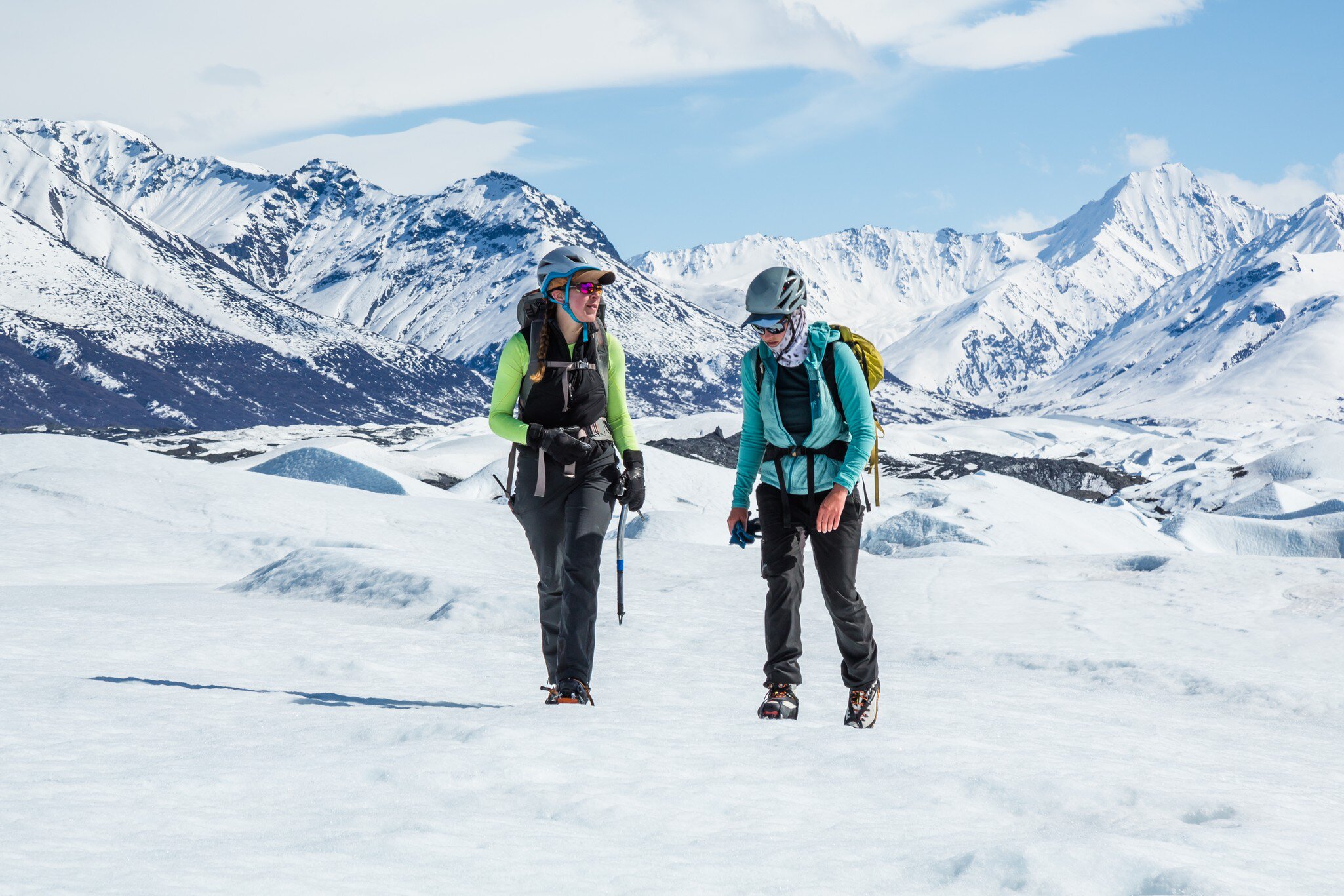 Two female glacier guides chatting while they trek across the Matanuska Glacier. Hiking in the Chugach Mountains on alpine glacier.  License Type: media  Download Time: 2024-02-14T02:17:53.000Z  User: FergalCo  Is Editorial: No  purchase_order: