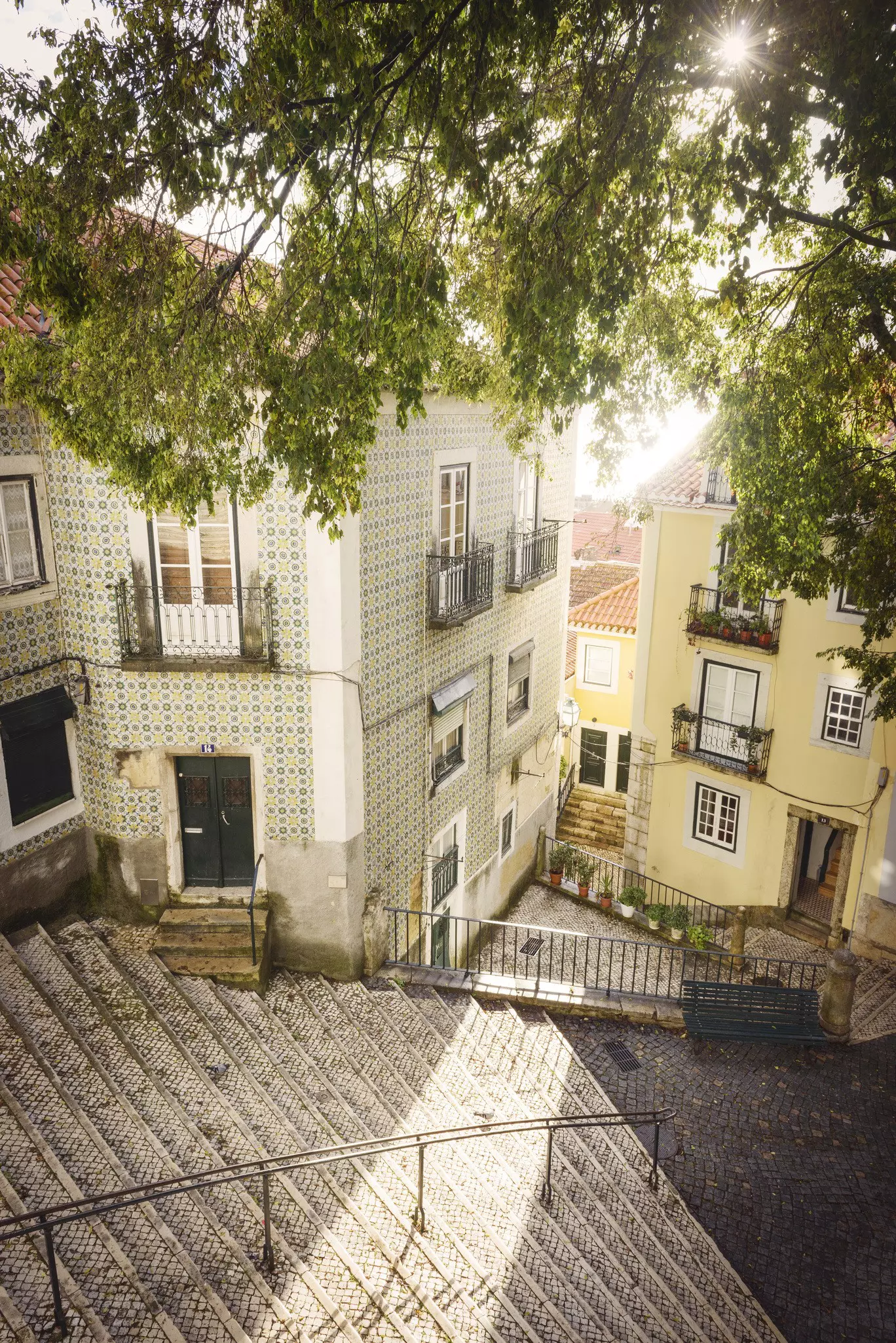 A downward angle of empty public steps surrounded by colourful buildings