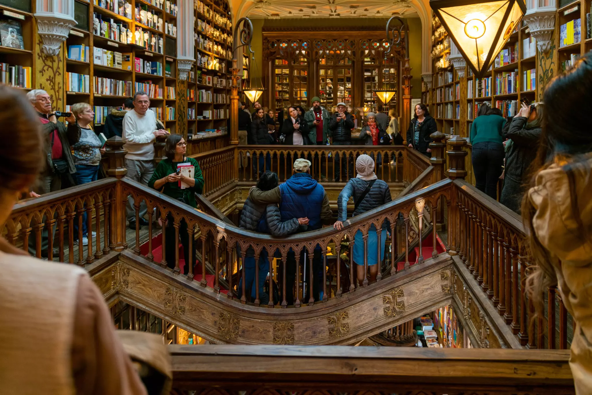 People taking photos on a walkway around an arcade inside a bookstore.