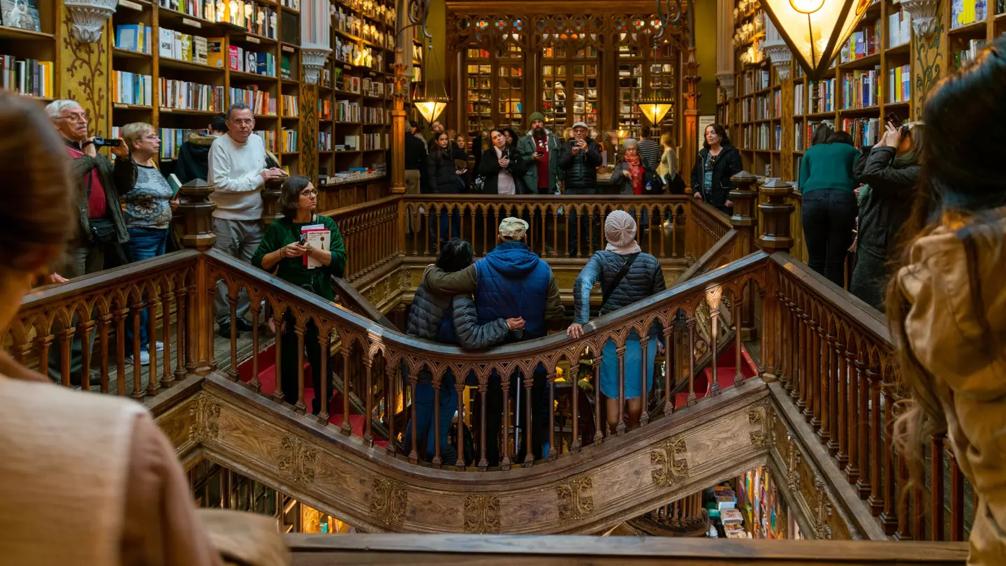 People taking photos on a walkway around an arcade inside a bookstore.