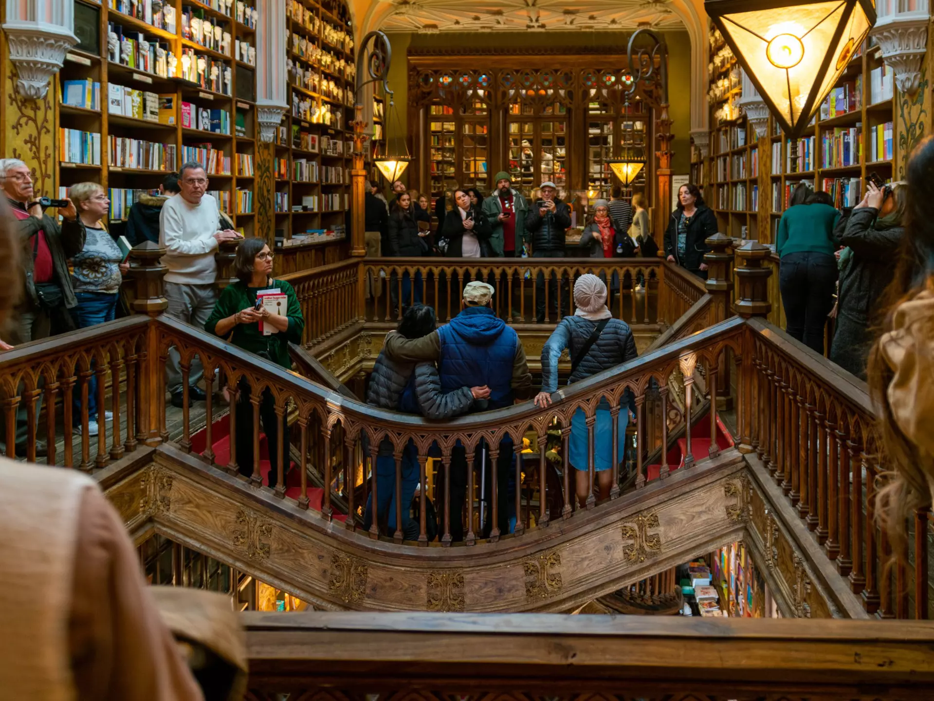 People taking photos on a walkway around an arcade inside a bookstore.