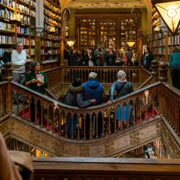 People taking photos on a walkway around an arcade inside a bookstore.