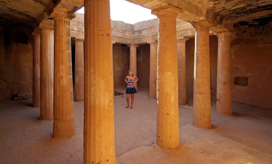 Women walking past the columns of the Tombs of the Kings, Cyprus