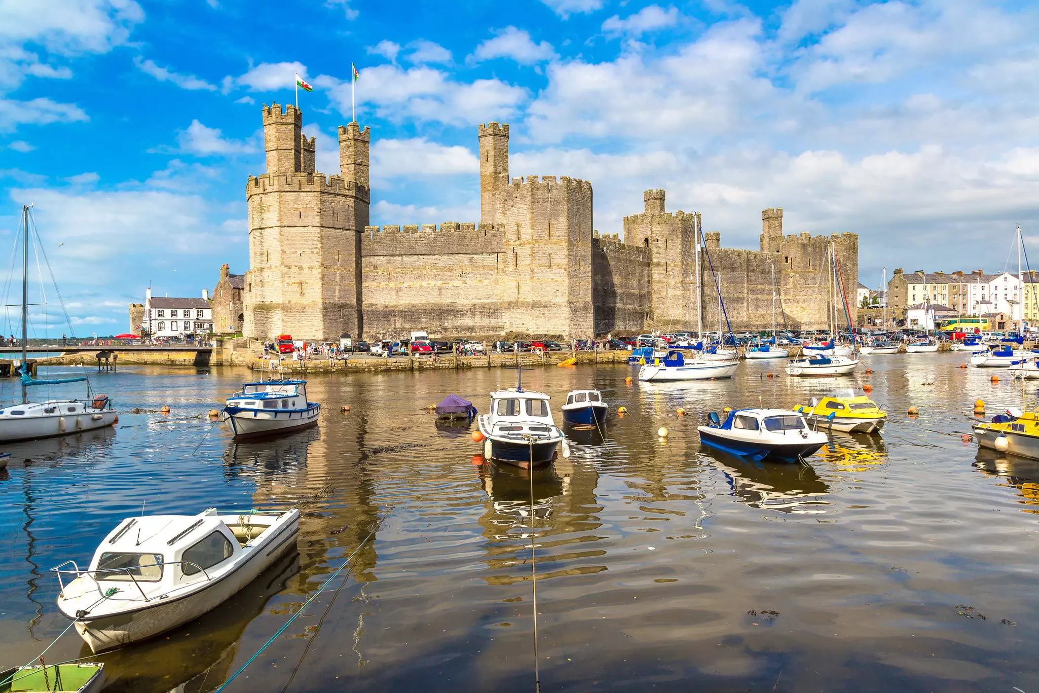 Boats in front of Caernarfon Castle in Wales in a beautiful summer day.