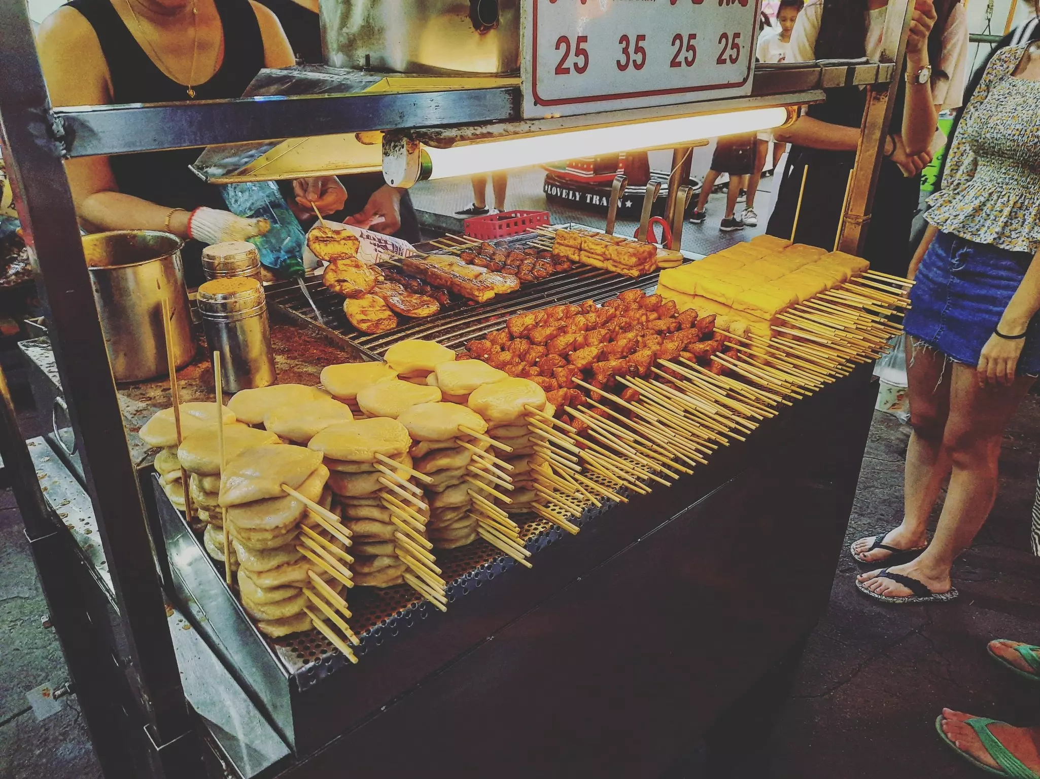 A vendor at a Taipei Night Market selling skewered barbecue (chuan shao 串烧) featuring Taiwanese fish cakes (tian bu la 甜不辣) and chicken (ji pi gu 雞屁股)