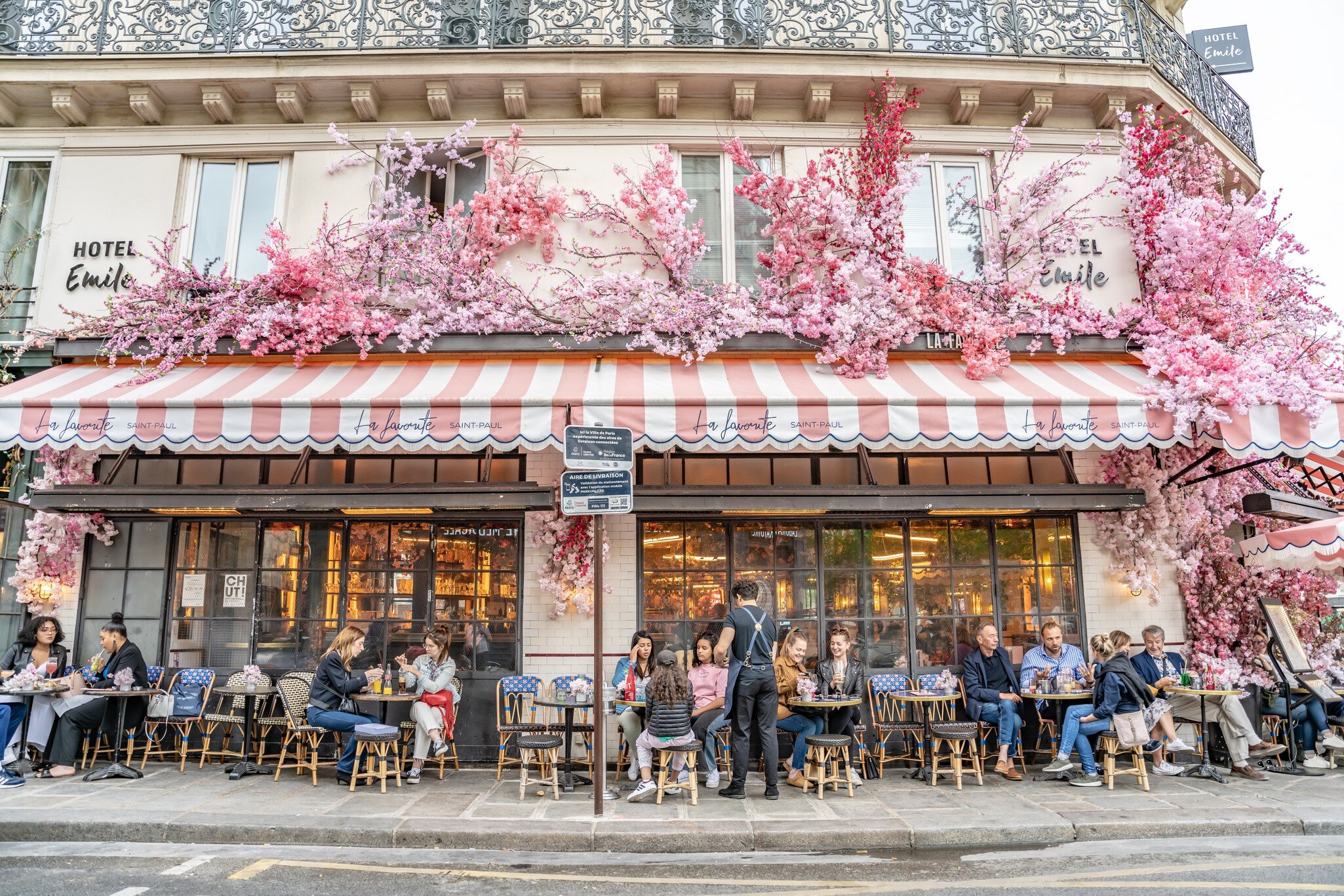 Paris, France. People enjoy dining at a traditional cafe in the city, with flowery, spring decor.