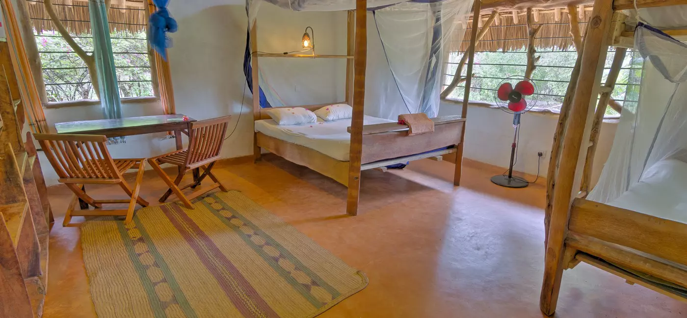 Two double beds with mosquito nets in a spacious dorm room