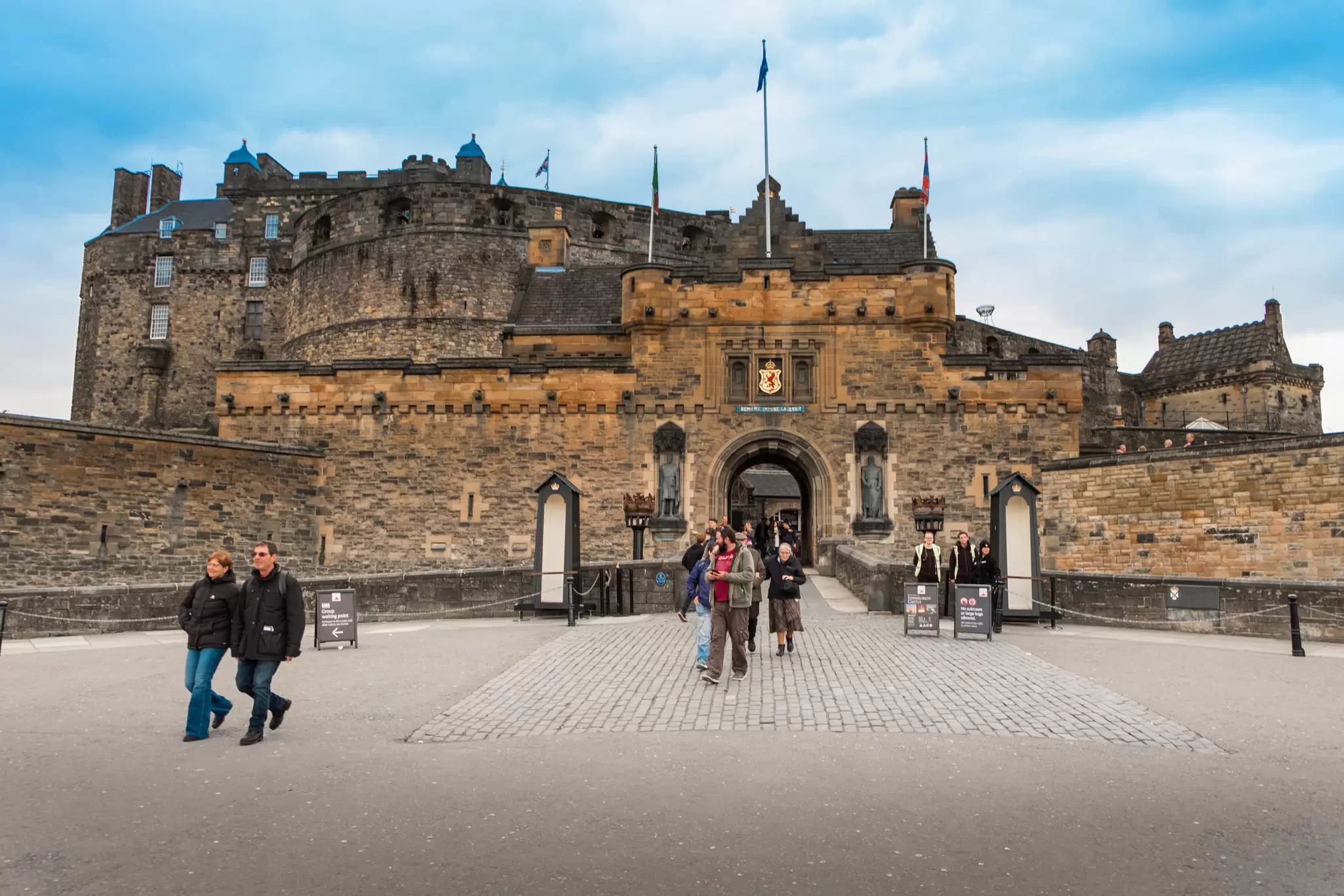 Visitors leaving through the main gate of a vast fortress
