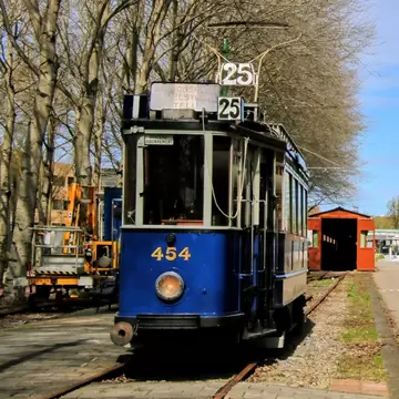 View of a historic blue tram of the Electrische Museumtramlijn Amsterdam on a sunny day.