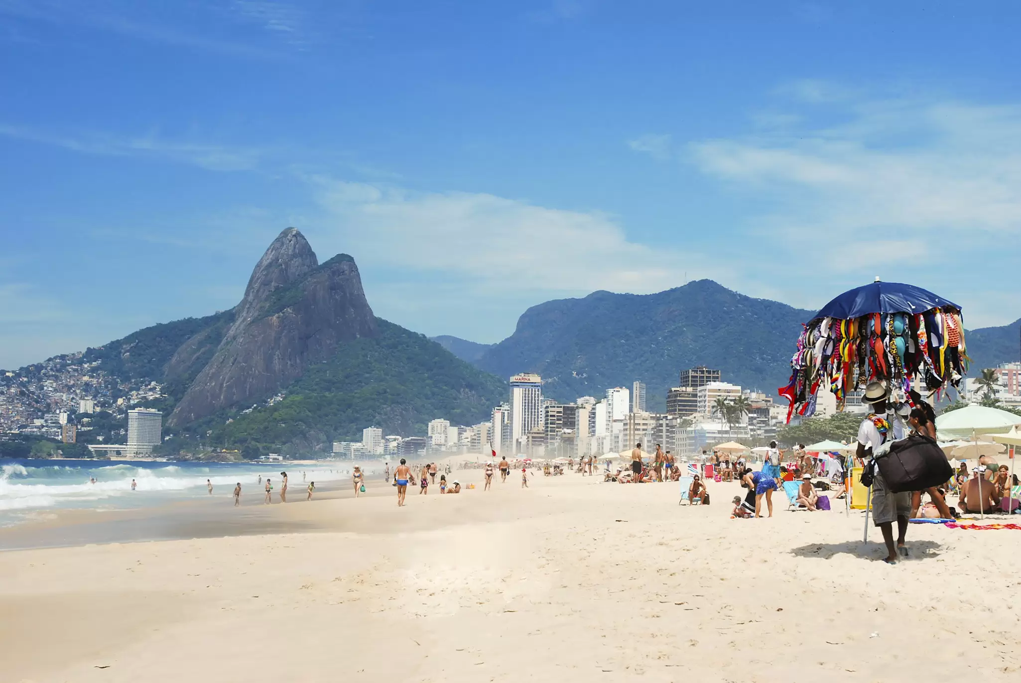 View of the vendedores ambulantes (salespeople) passing along Ipanema Beach in Rio de Janeiro, Brazil.