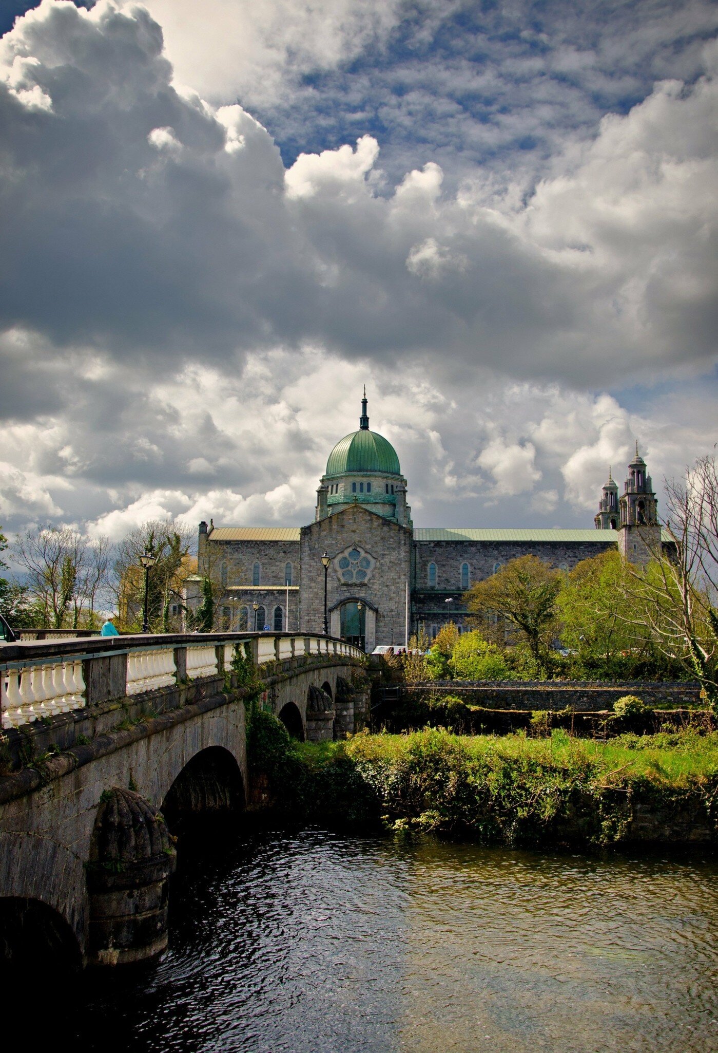 Blue cloudy sky and bridge leading to Galway Cathedral in Galway, Ireland. 