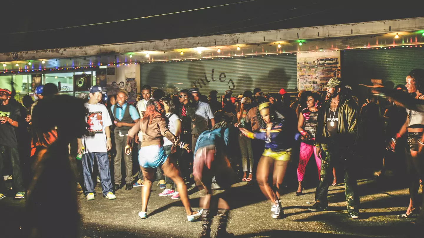 A crowd of dancers on a street in Kingston at night.