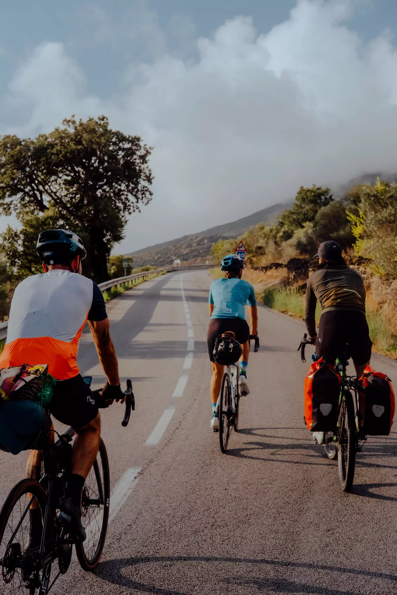 Three cyclists on a winding road.