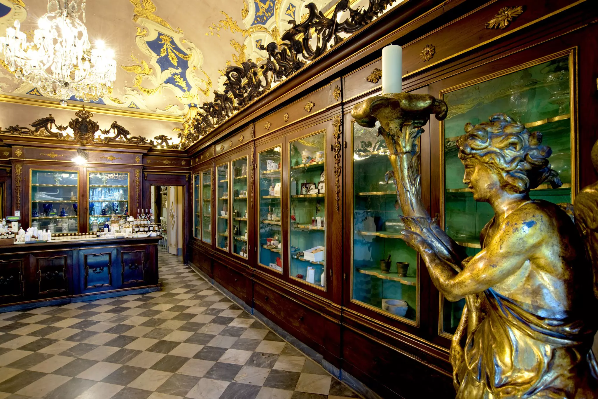 A large room lined with floor-to-ceiling wooden cabinets where antique apothecary items are on display.