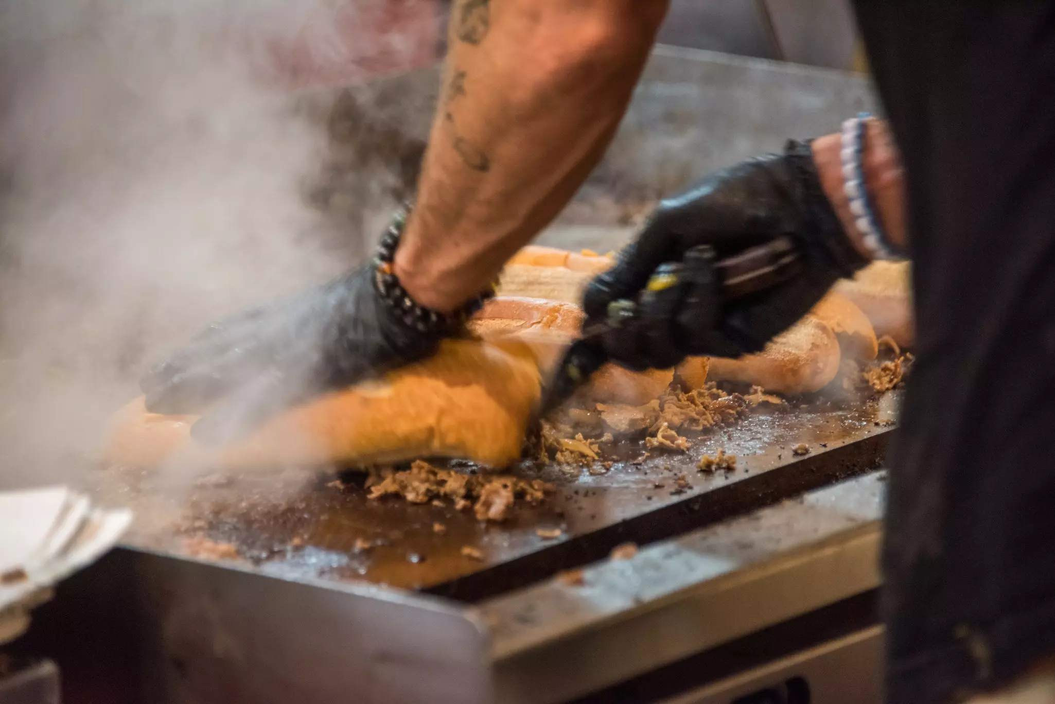 Thinly sliced rib-eye steak being cooked on a griddle to prepare Philly cheesesteak in Philadelphia, Pennsylvania, USA.