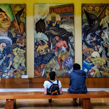 Visitors at the Palacio de Bellas Artes in Mexico City look at Diego Rivera’s 'Carnaval de la vida mexicana' mural.