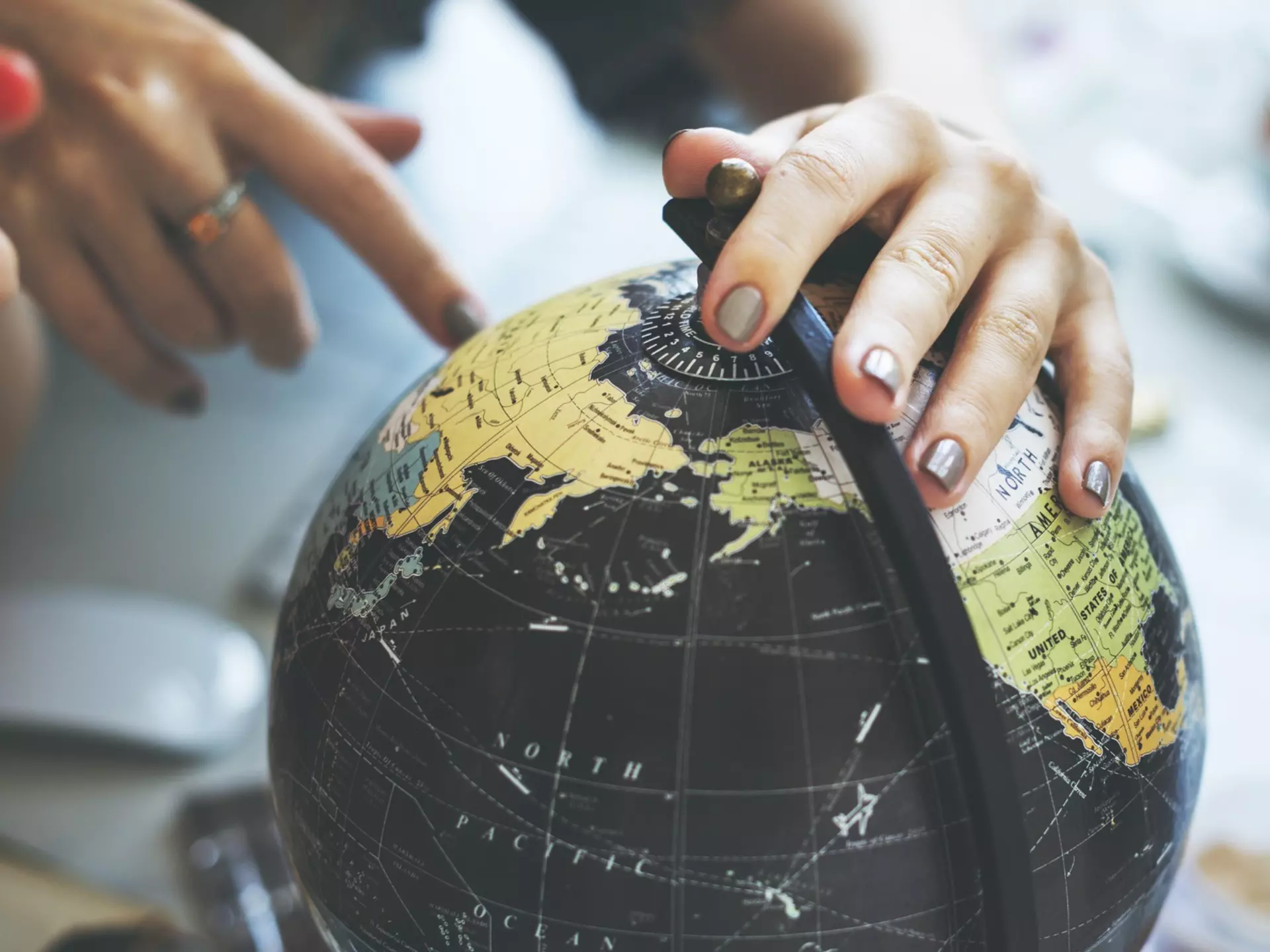 Woman's hand placed on spinning globe