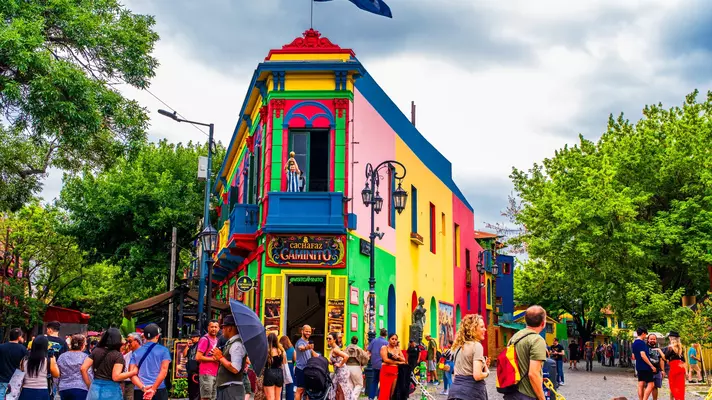 People gathered in front of a multicolored building in Buenos Aires.