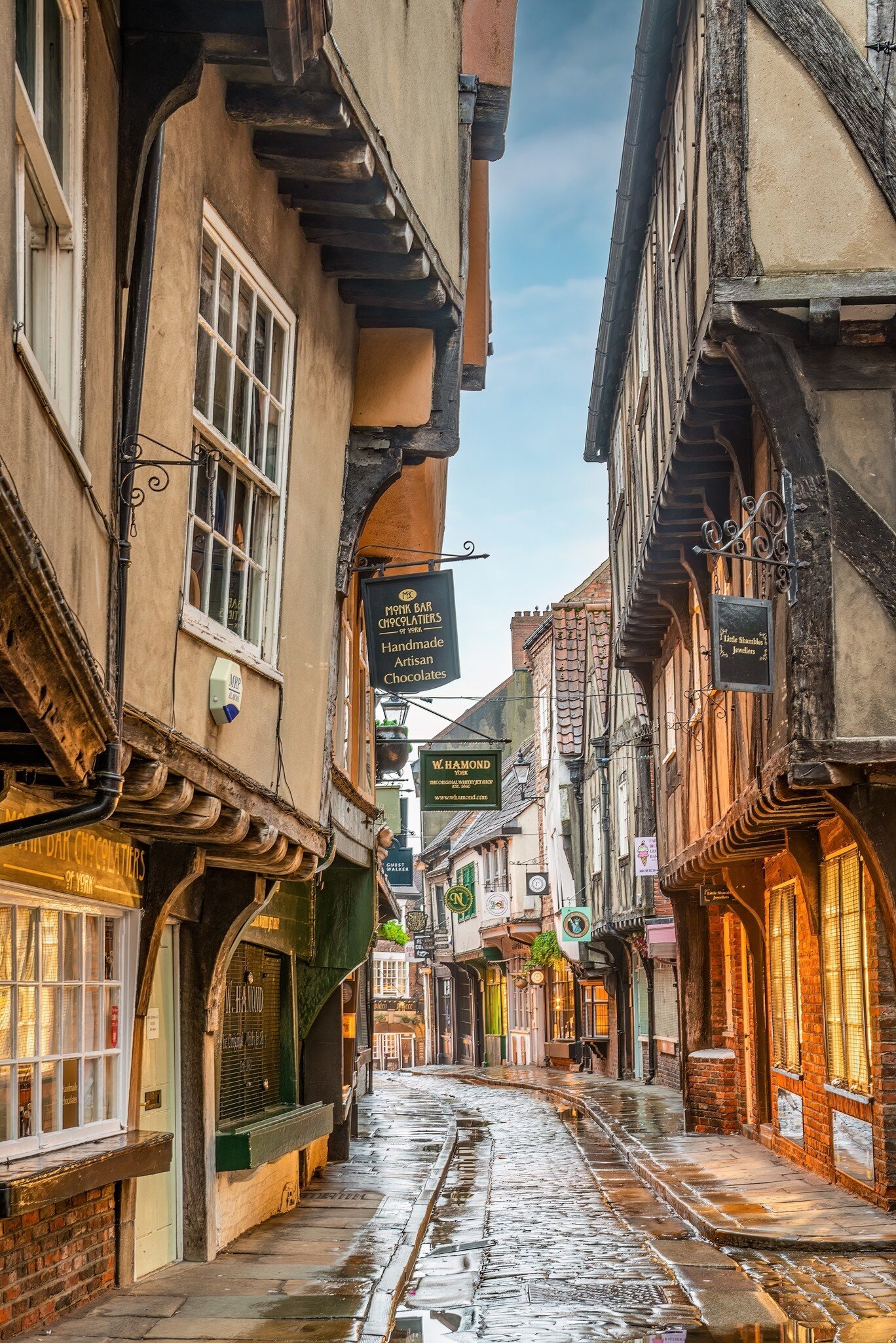 A narrow medieval street with half-timbered houses leaning over the cobbles.