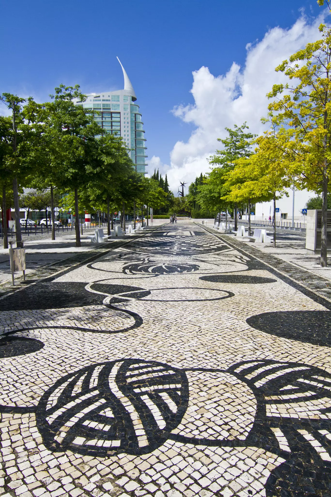 Black and white tiles lead into parkland lined with contemporary architecture.