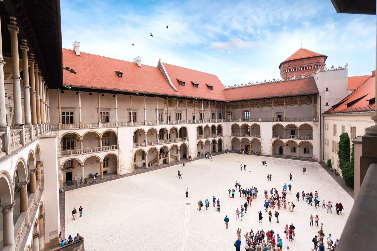 People walking around a courtyard at Wawel Royal Castle in Kraków.
