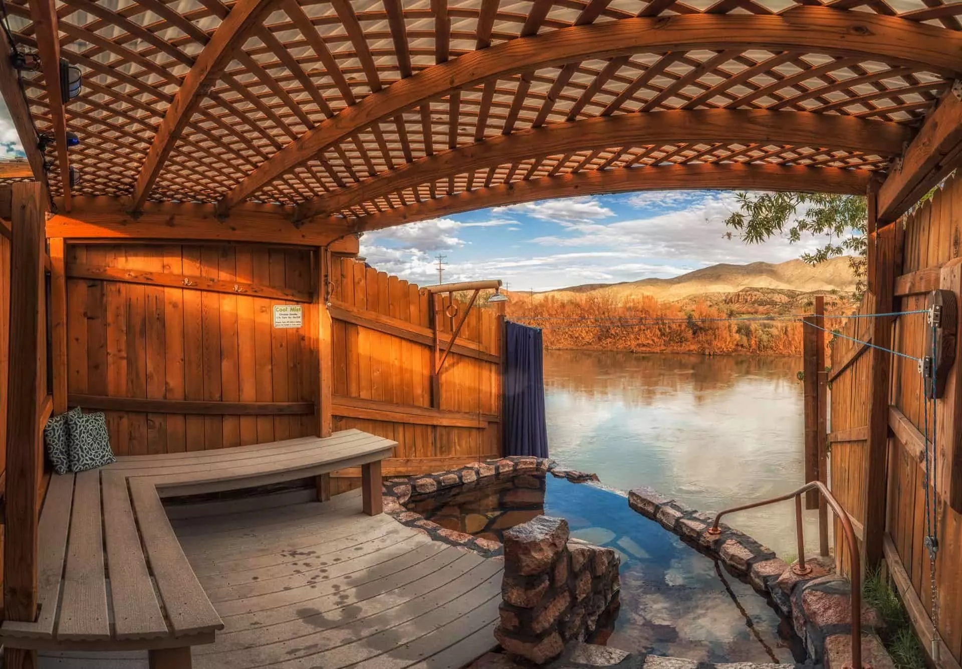 A wood enclosure around a small pool by a river.