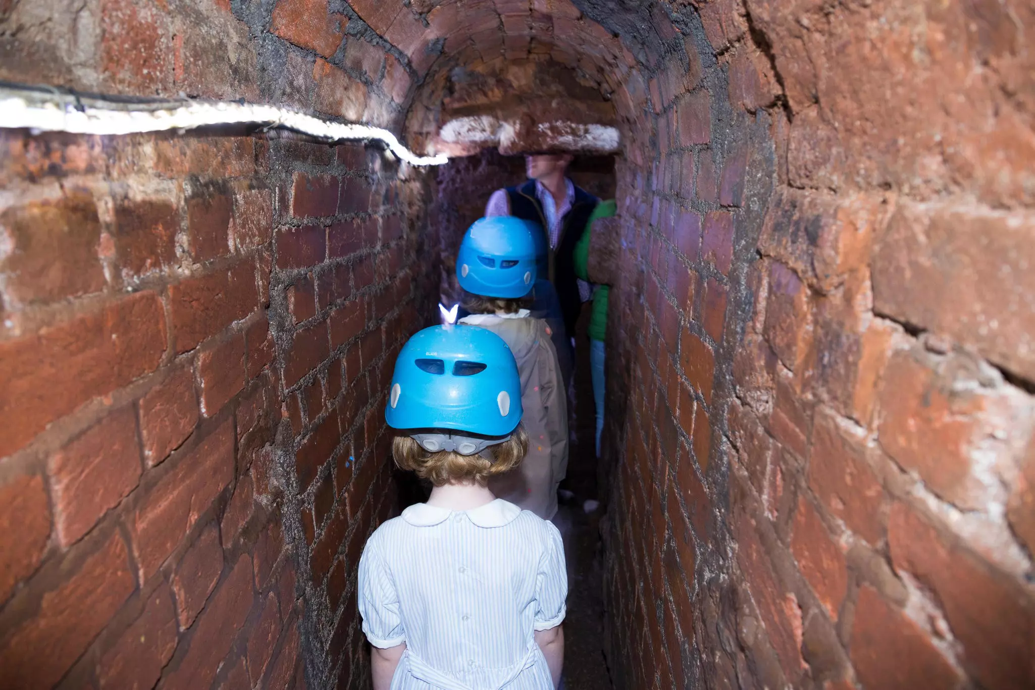 A family group squeezing through Exeter's spooky Underground Passages.