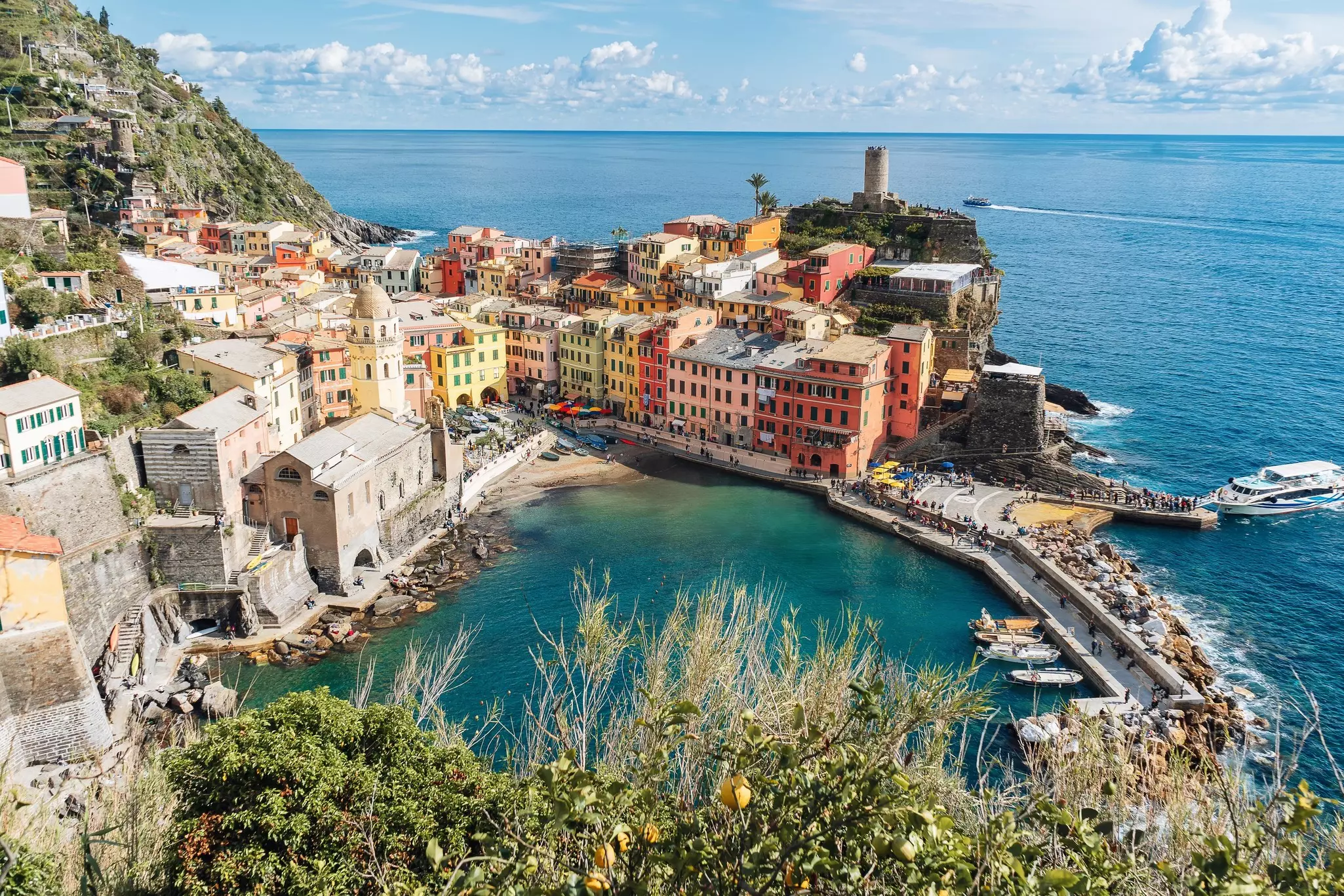 A seaside town of pastel-colored buildings glowing in the spring sunshine