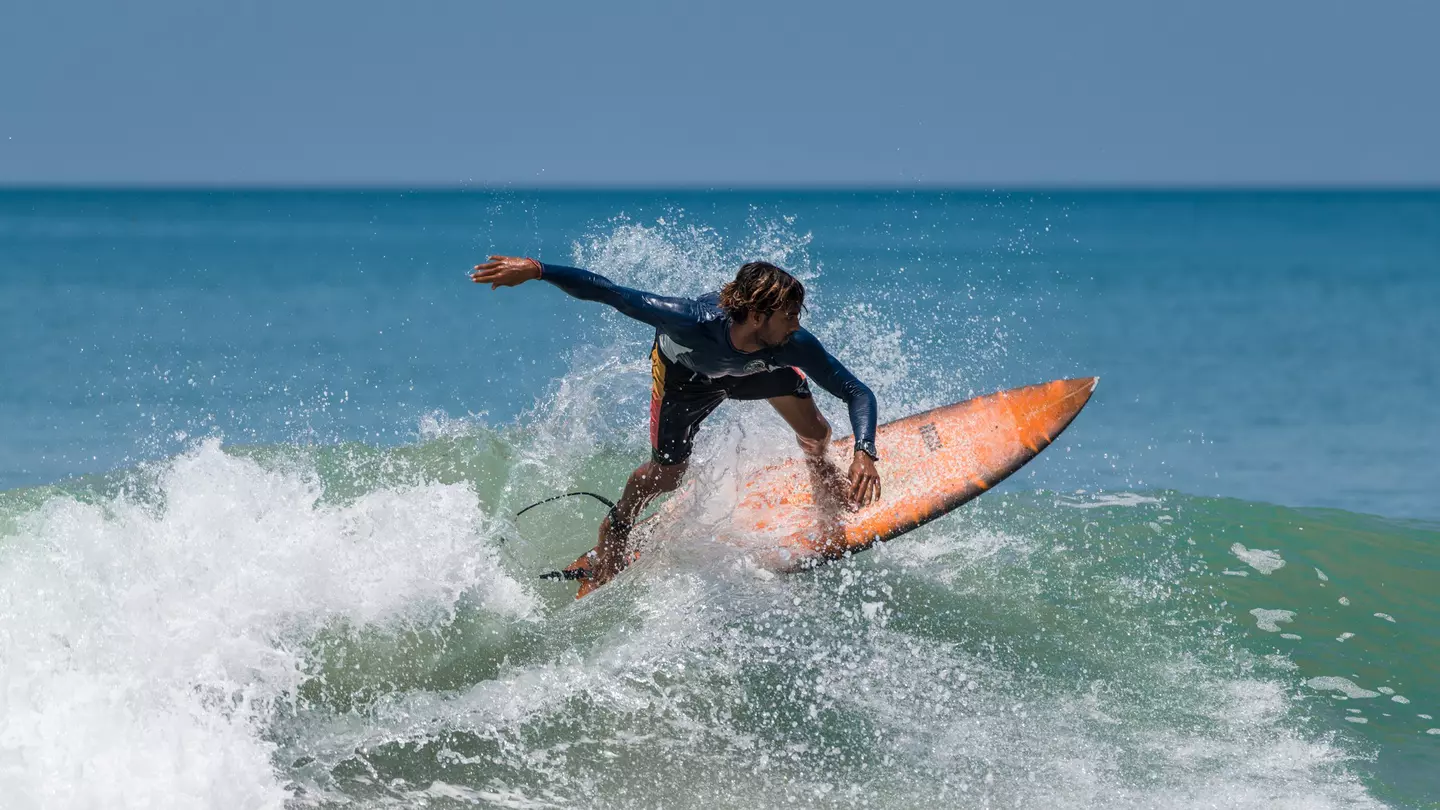 A surfer on the beach at Varkala in Kerala, India.