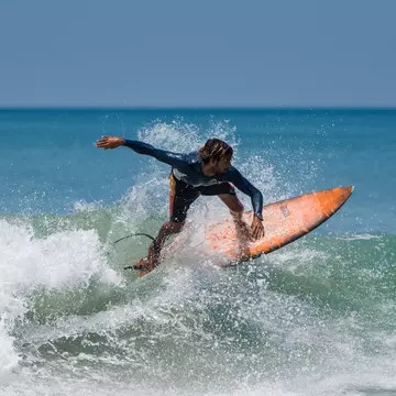 A surfer on the beach at Varkala in Kerala, India.
