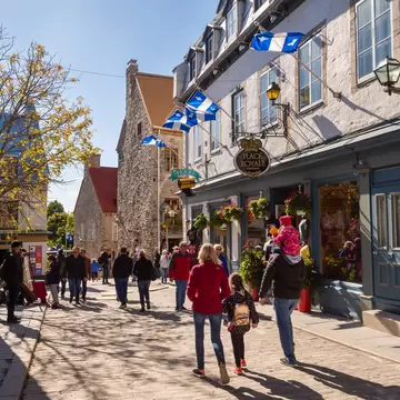 Quebec City, Canada - 5 October 2019: Quebec flags on Notre-Dame street.