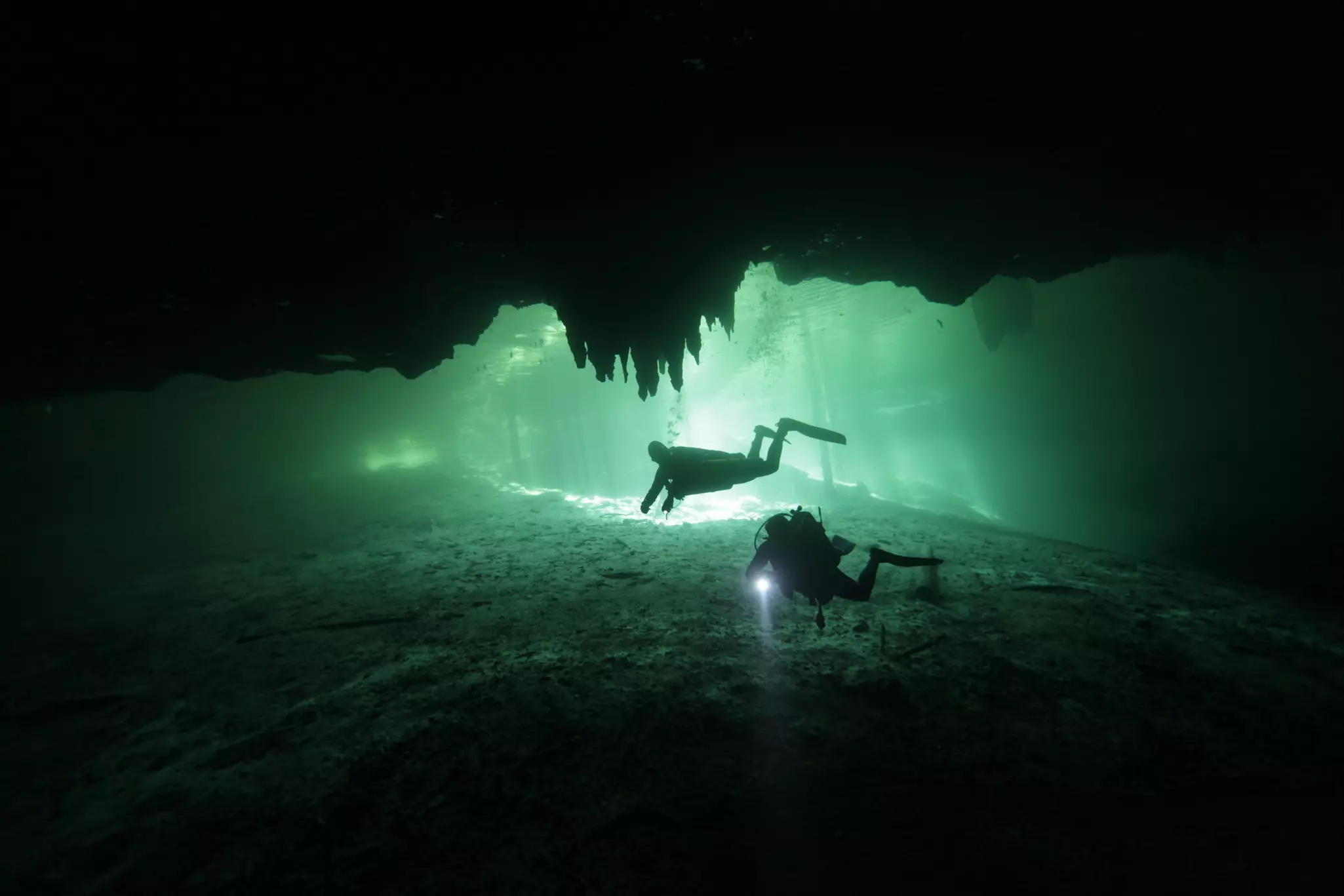 Divers underwater in the cenote Dreams Gate at Playa del Carmen