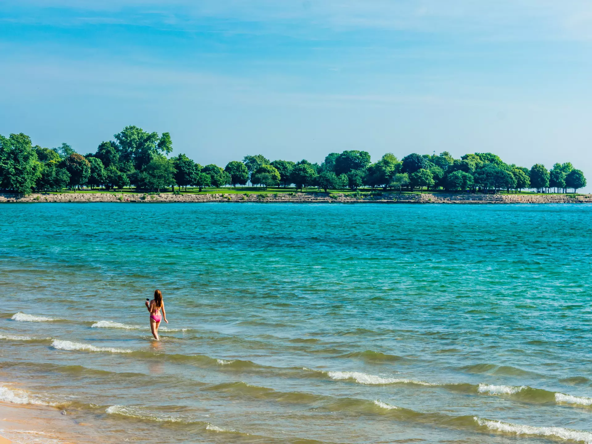 A woman walking in the shallows at 57th Street Beach in Chicago