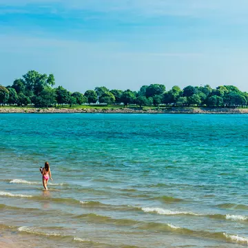 A woman walking in the shallows at 57th Street Beach in Chicago