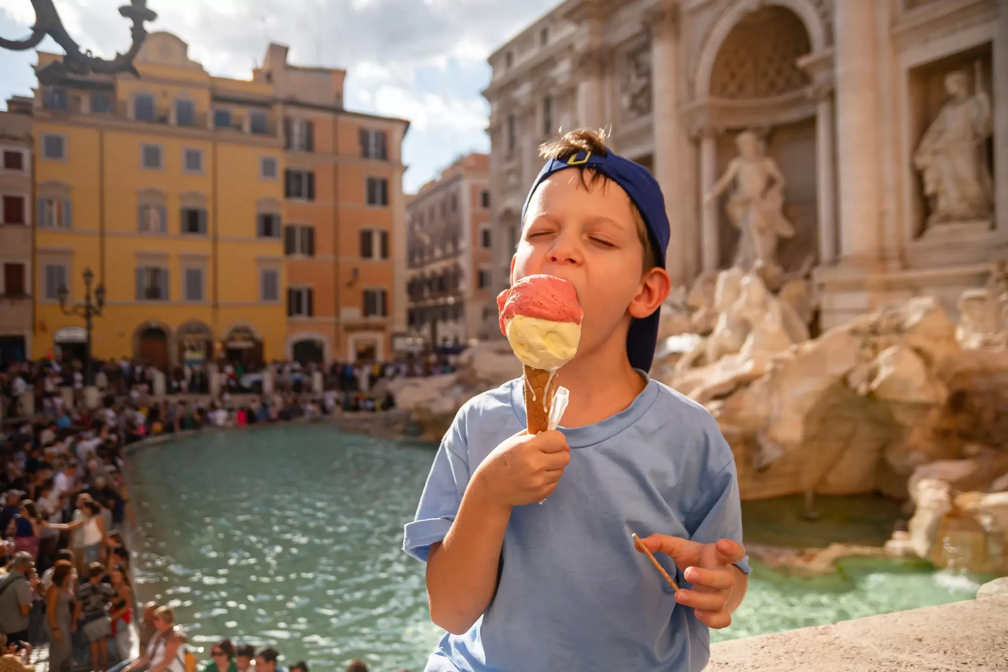 Boy eating gelato near the Trevi Fountain in Rome, Italy
