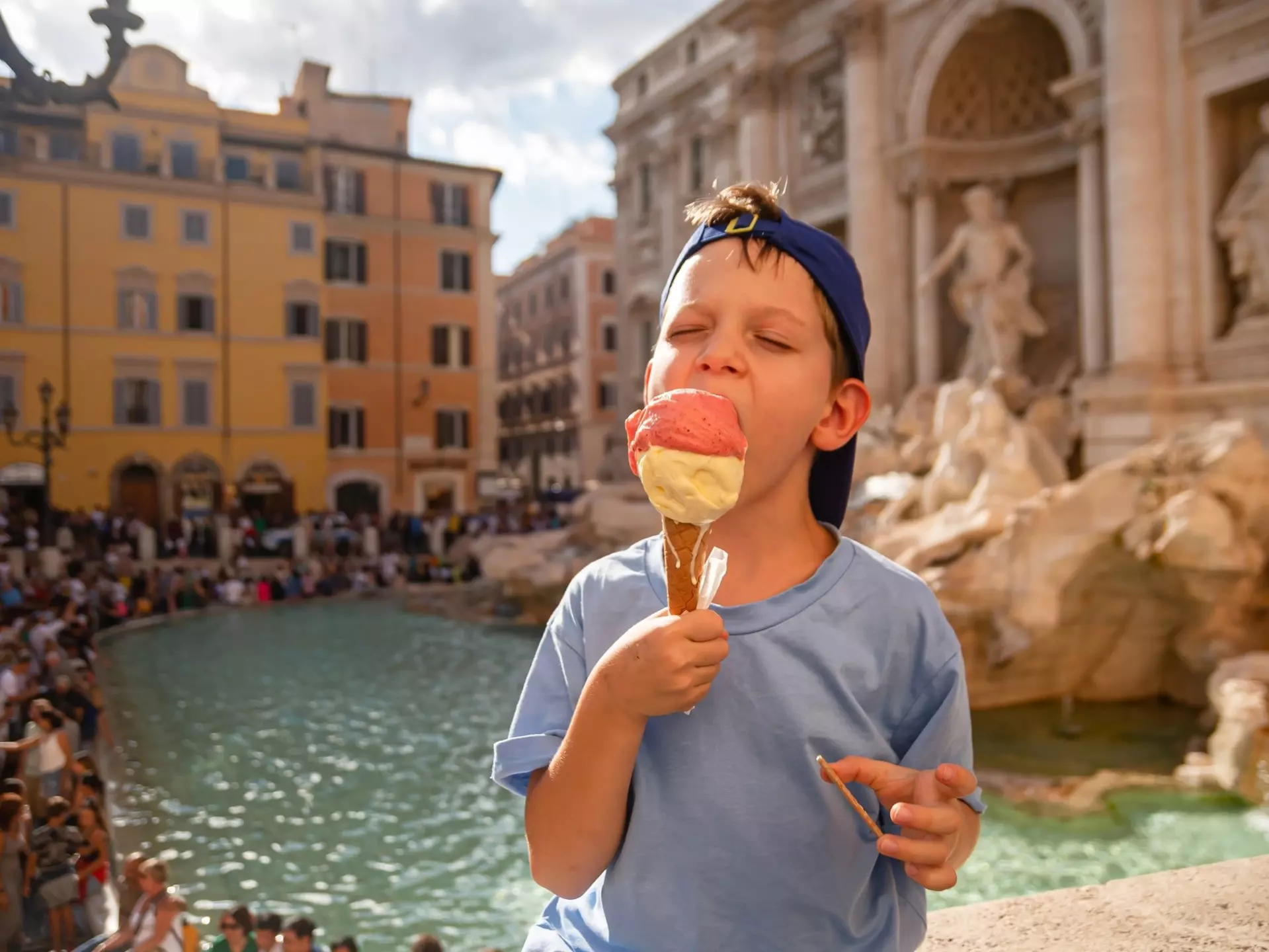 Boy eating gelato near the Trevi Fountain in Rome, Italy
