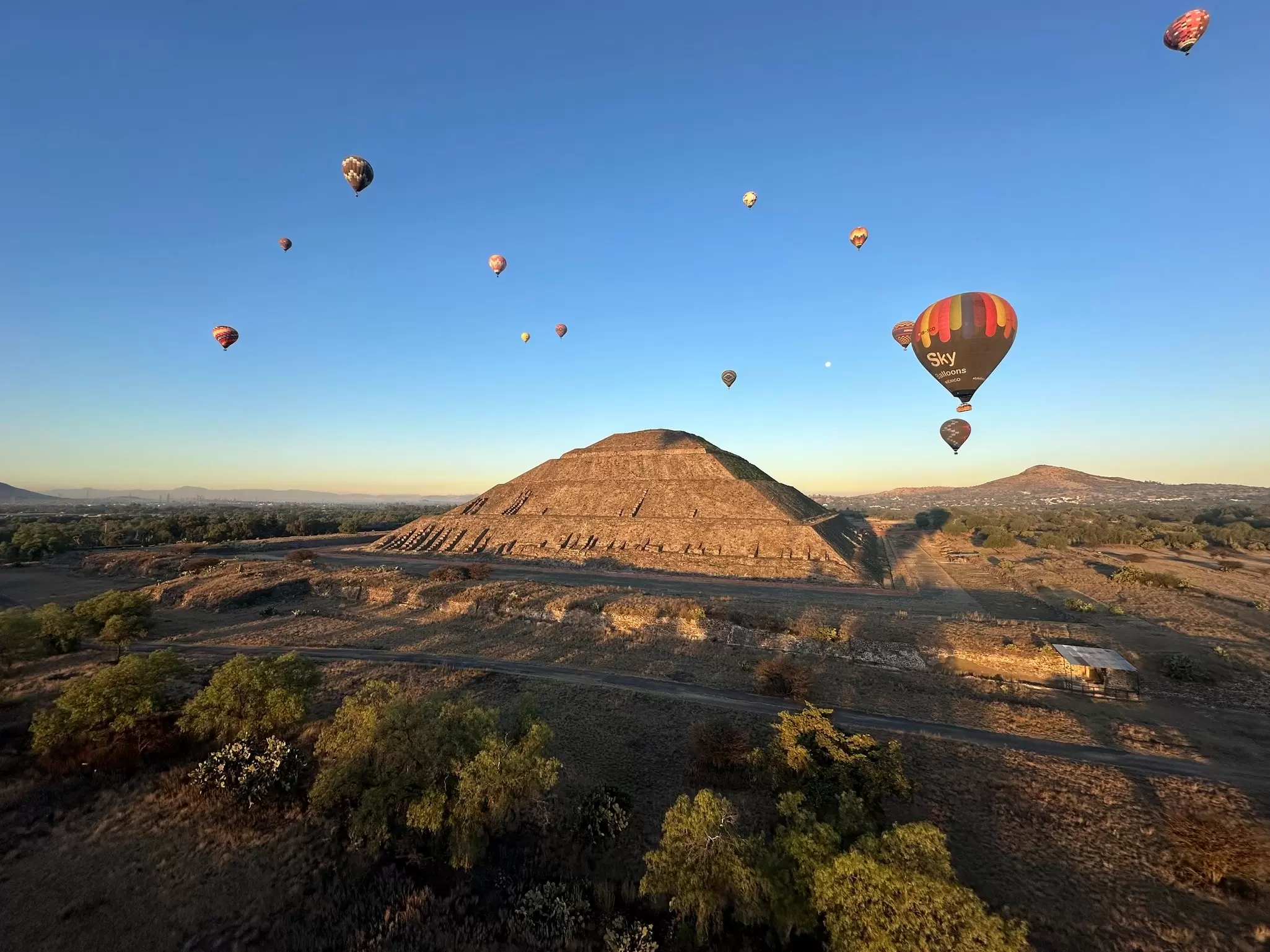 View of Teotihuacán from a hot air balloon during a weekend tour with other hot air balloons also floating above