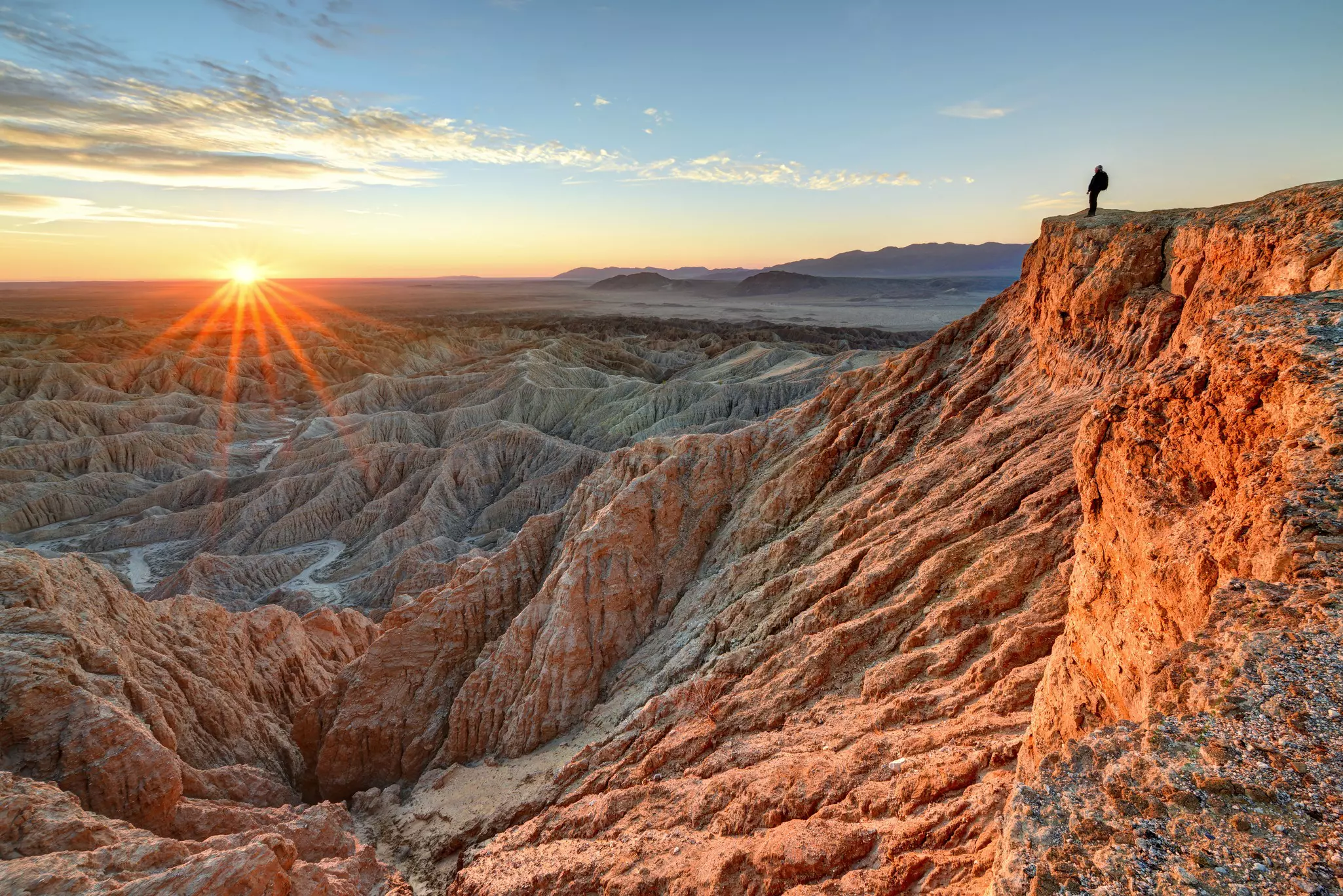 Hiker standing above the Anza-Borrego Desert State Park Badlands at sunrise   License Type: media  Download Time: 2023-08-31T00:57:49.000Z  User:   Is Editorial: No  purchase_order: