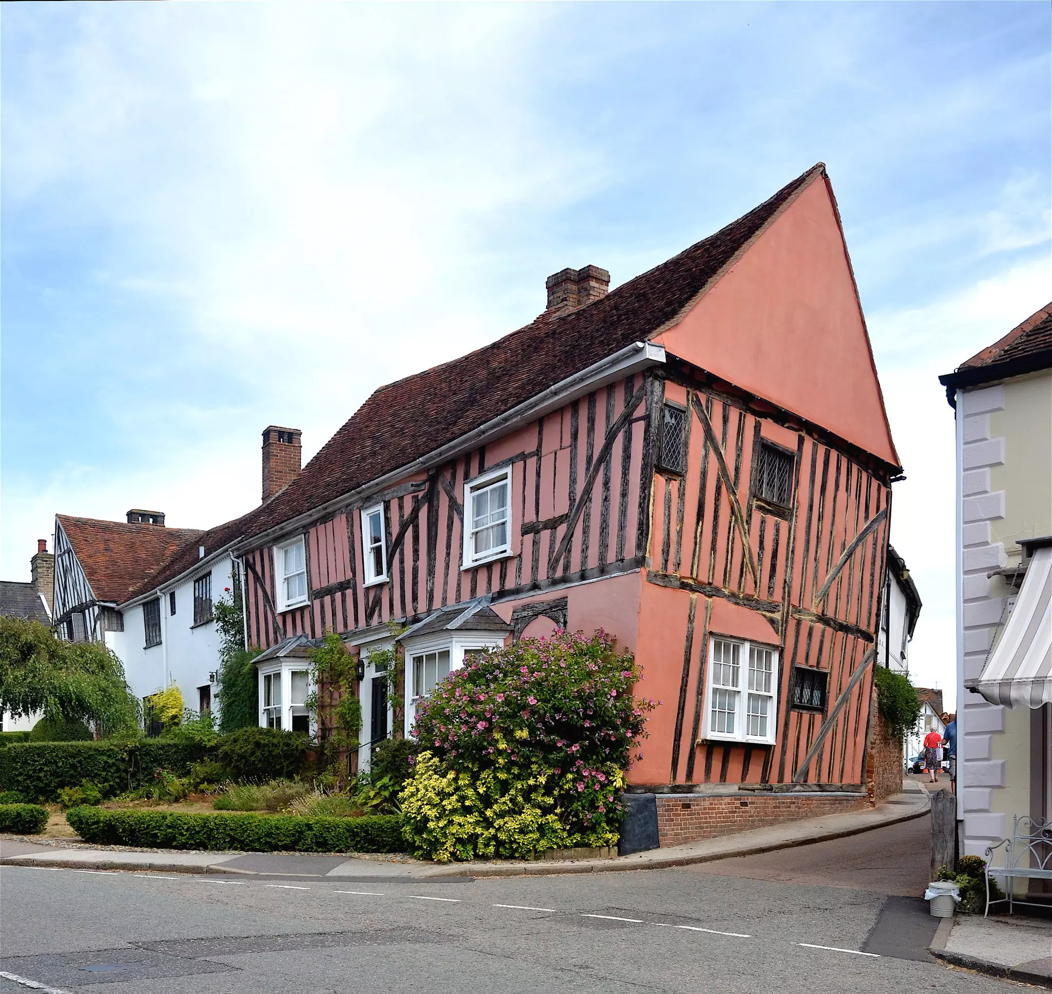 A large cottage with a distinctive lean at the corner of a street.