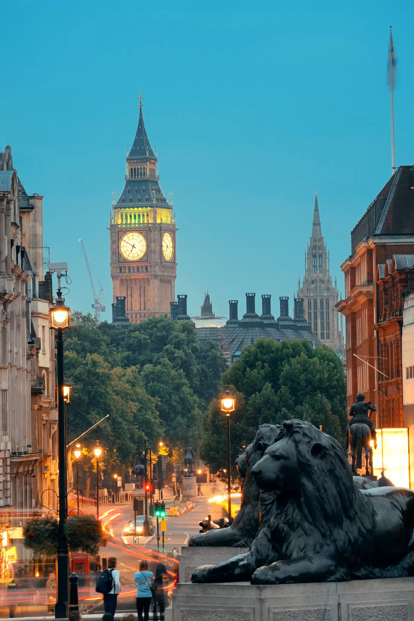 View of the lion statues on Trafalgar Square at night in London, UK.