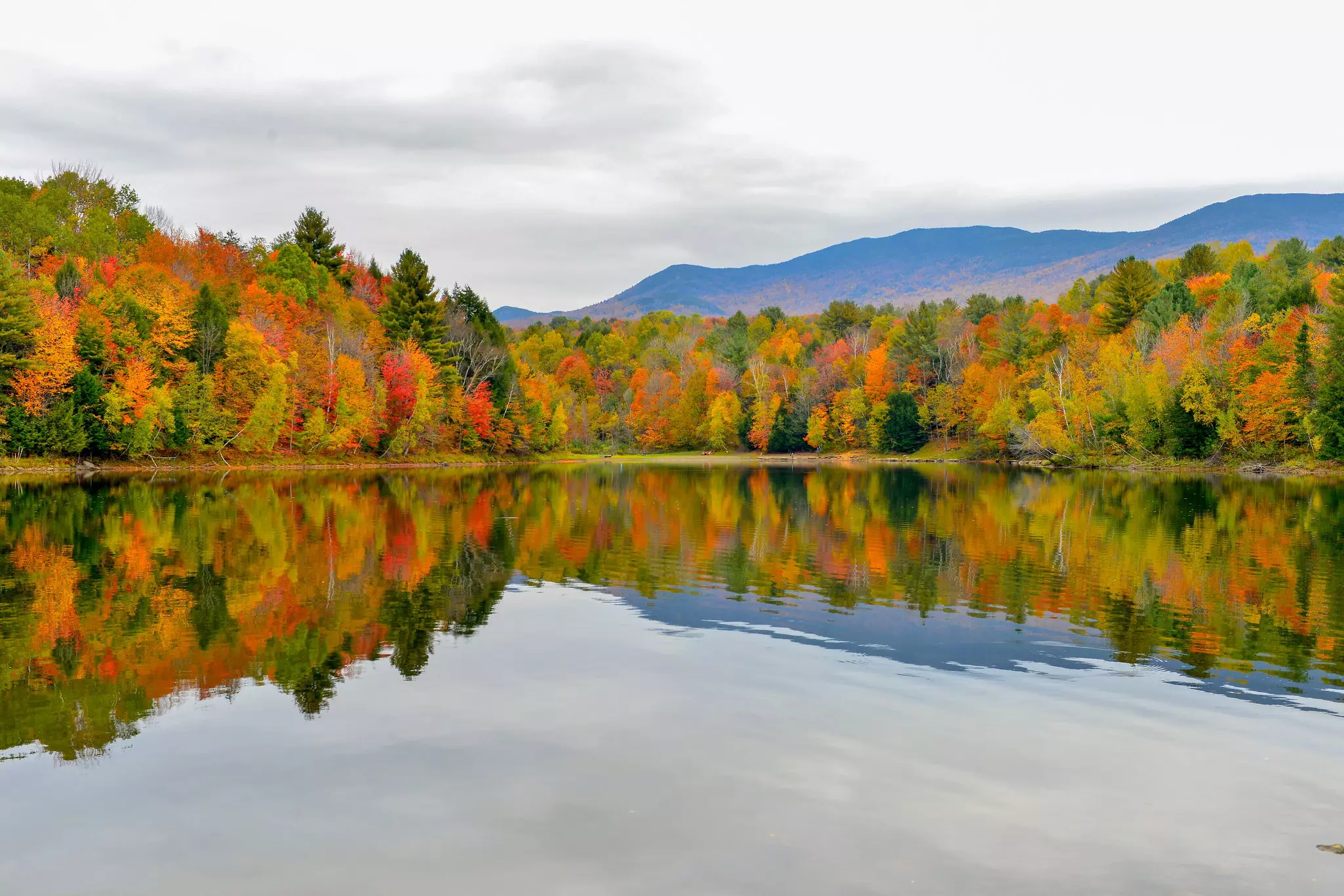 Autumn forest and mountains reflected in the Waterbury Reservoir near Stowe, Vermont