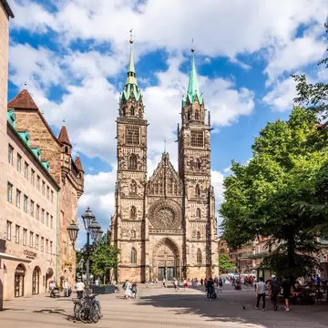 West facade of St. Lorenz church (Lorenzkirche) dominated by the two towers with a sharp towering West portal doorway and a 9-meter rose window. Nuremberg, Germany.