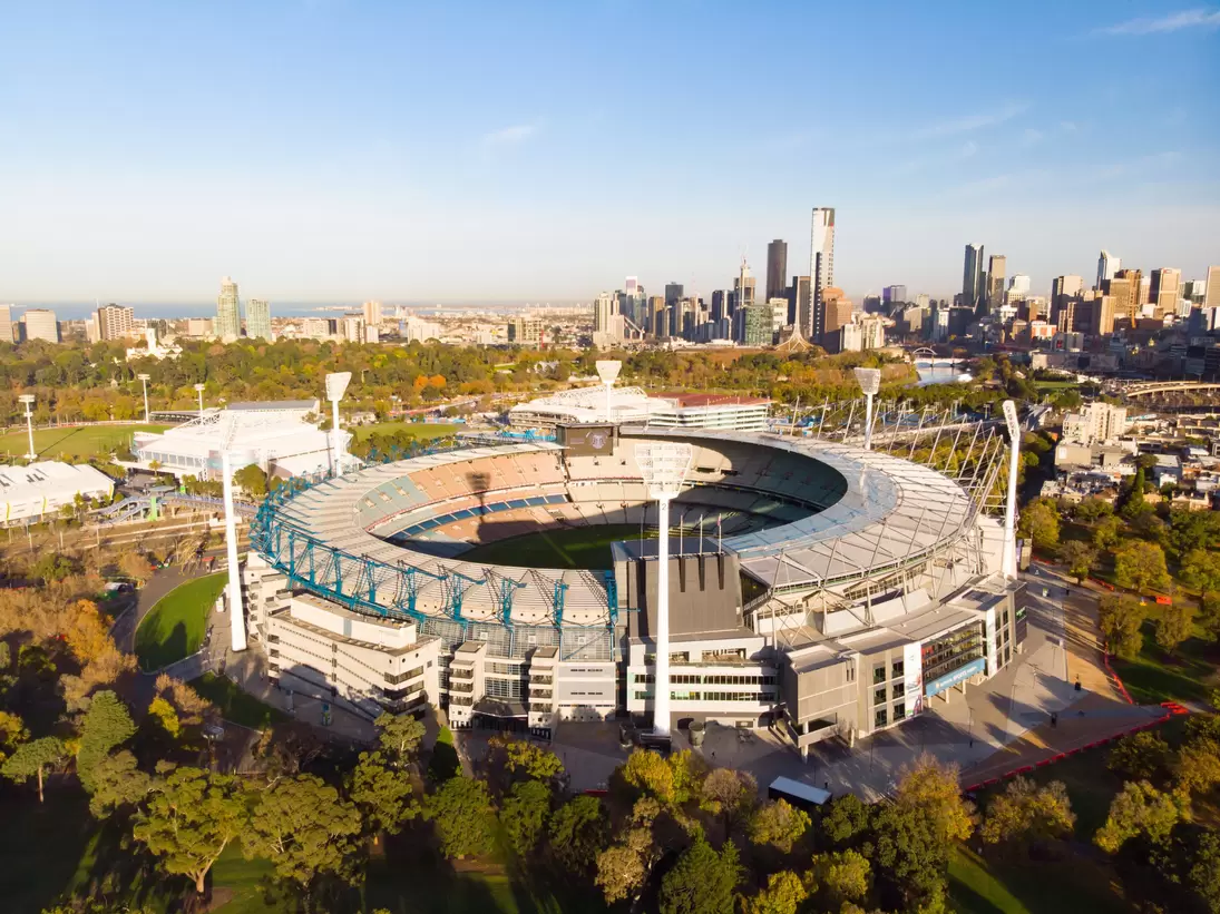 Aerial view of Melbourne's famous skyline with the Melbourne Cricket Ground stadium in the foreground on a cool autumn morning in Australia.