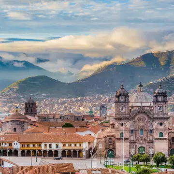 A large fountain and Cusco Cathedral in Plaza-de-Armas.