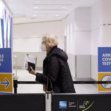 Travelers arrive at the Pearson International Airport in Toronto, Canada, on March 26, 2020. Canada imposed a 14-day mandatory self-isolation rule for any traveler returning to Canada.