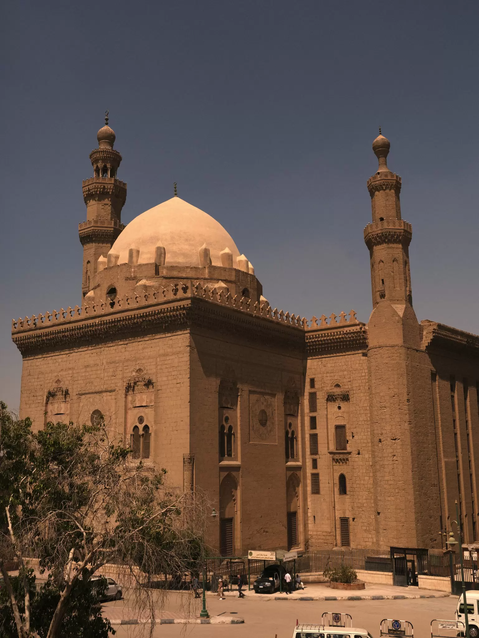 The exterior of a mosque in Cairo, Egypt with two columns and a dome. 